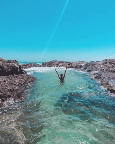 A swimmer in the natural rock pools at Snapper Rocks, Coolangatta