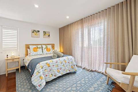 Queen bedroom with lemon-print linen and full-height sheer curtains