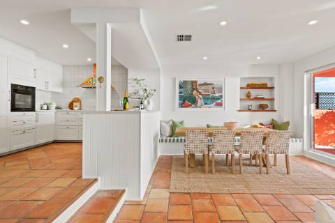 White kitchen and dining area with terracotta floor tiles