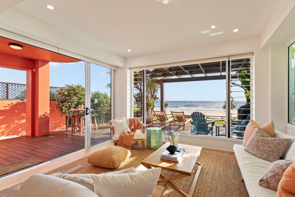 Open-plan living room at the Palm Beach house opening onto the terracotta beachfront terrace and ocean